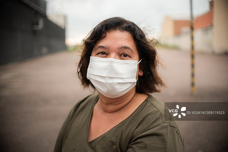 中年妇女在面具后面微笑图片素材