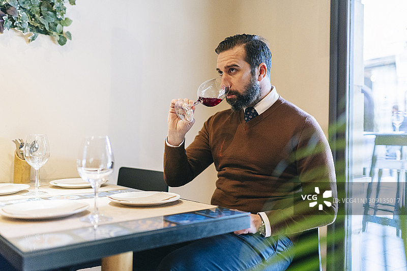 男人啜饮一杯葡萄酒图片素材