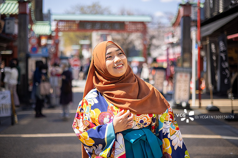 穿着和服戴着头巾在城市里行走的女学生图片素材