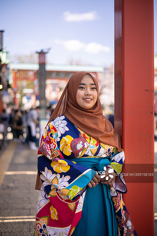 穿着和服和盖头的女学生站在城市里图片素材
