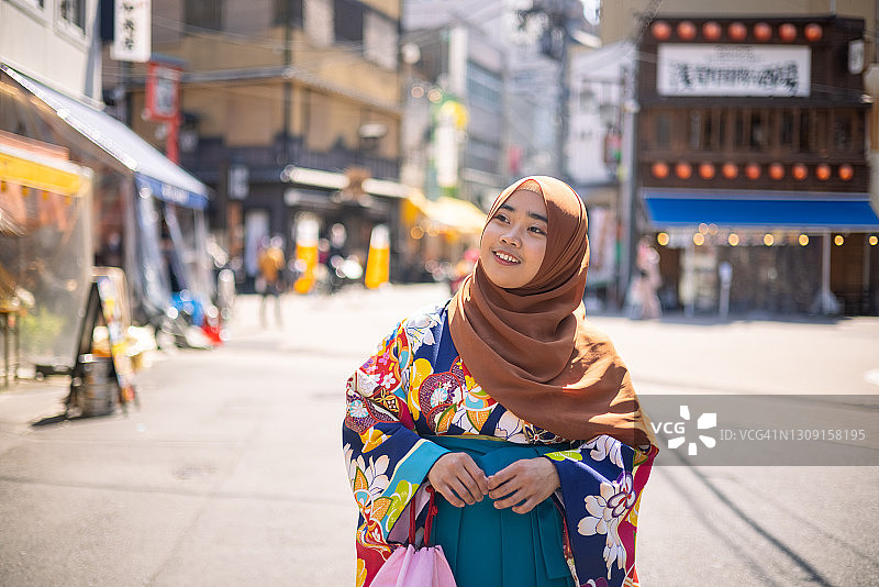 戴着头巾、身穿和服的女学生走在街上图片素材
