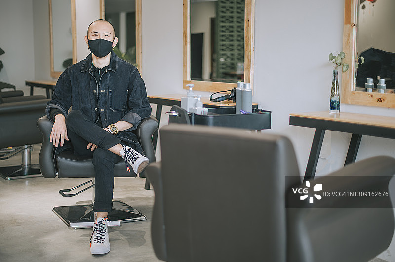 戴口罩的华人发型师自信地看着镜头图片素材