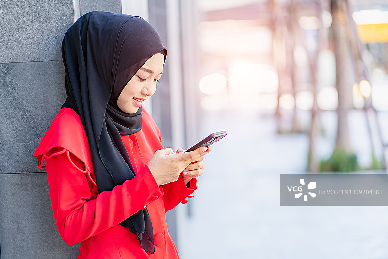 使用智能手机的快乐穆斯林女性图片素材