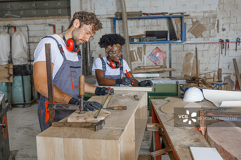 木匠用卷尺测量木板，准备切割图片素材