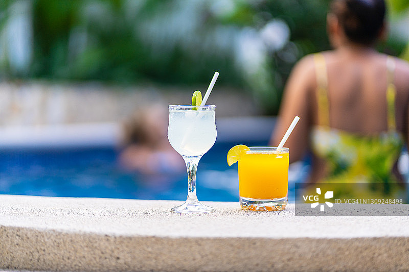 聚焦游泳池边的两杯鸡尾酒图片素材