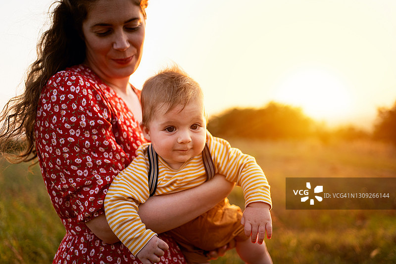 美丽的母亲在户外抱着她的男婴图片素材