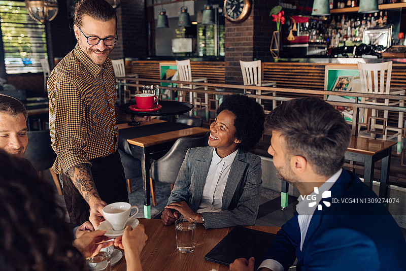 服务员为商务会议中的一群人送咖啡图片素材