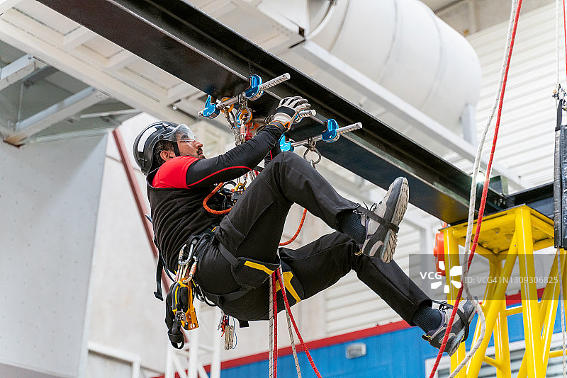 年轻男人使用攀岩设备进行训练图片素材