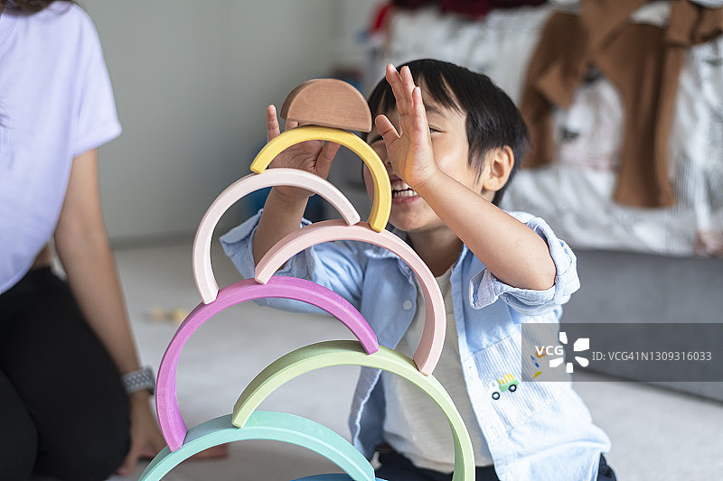 快乐的幼儿男孩在家和妈妈一起玩图片素材