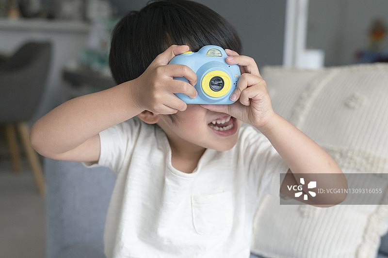 玩玩具相机的可爱幼儿男孩图片素材