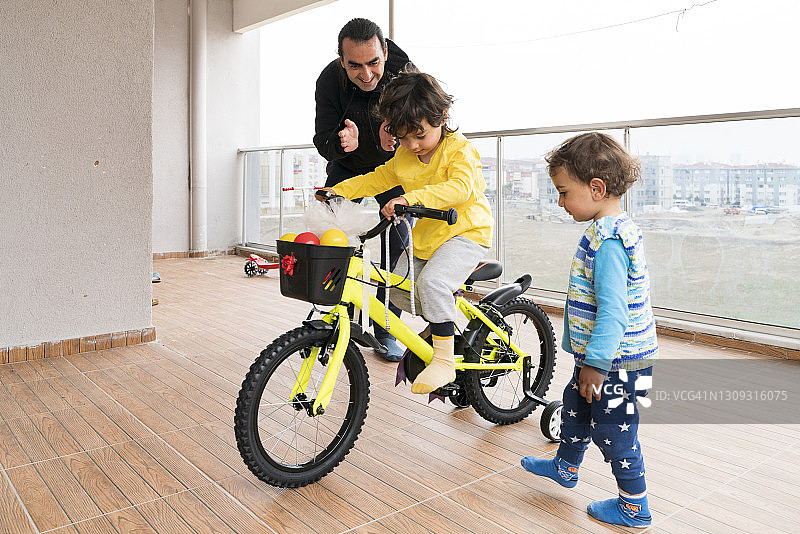 父亲把买的自行车作为礼物送给儿子图片素材