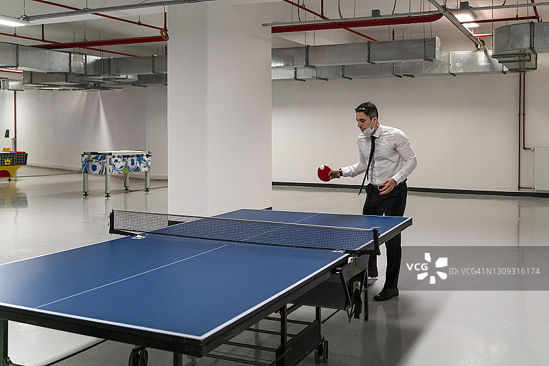 在办公楼生活区打乒乓球的职员图片素材