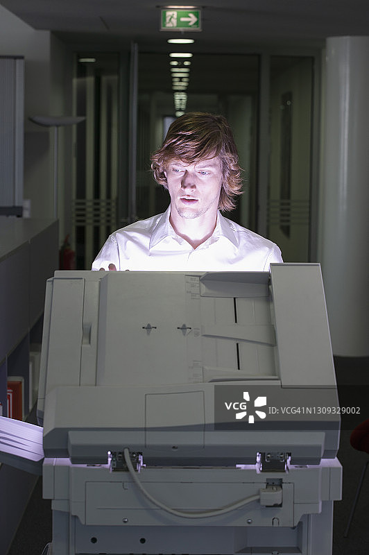 年轻商人在办公室使用复印机图片素材