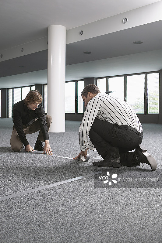 商人在新办公室测量并标记地板图片素材