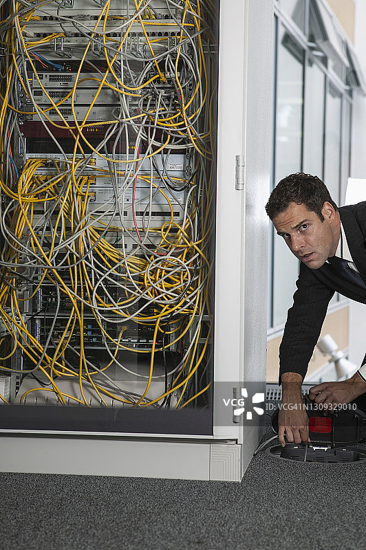 正在拔网络服务器插头的可疑商人 портрет图片素材