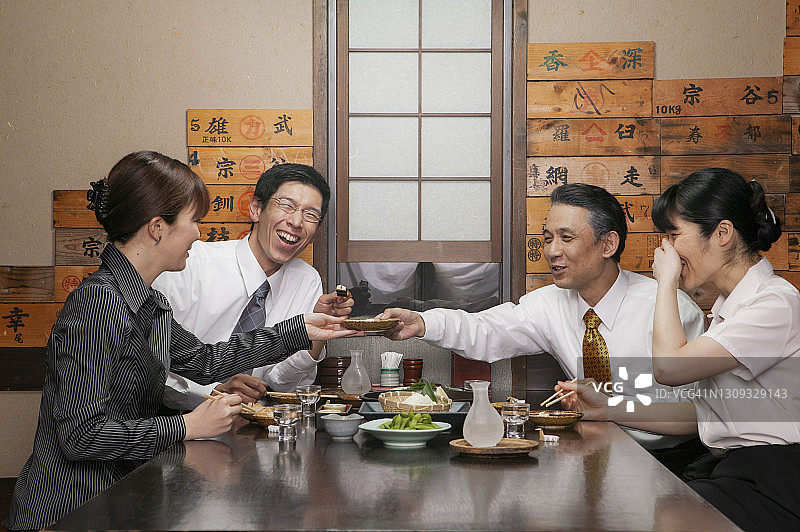 快乐的日本商人在餐厅享用寿司午餐图片素材