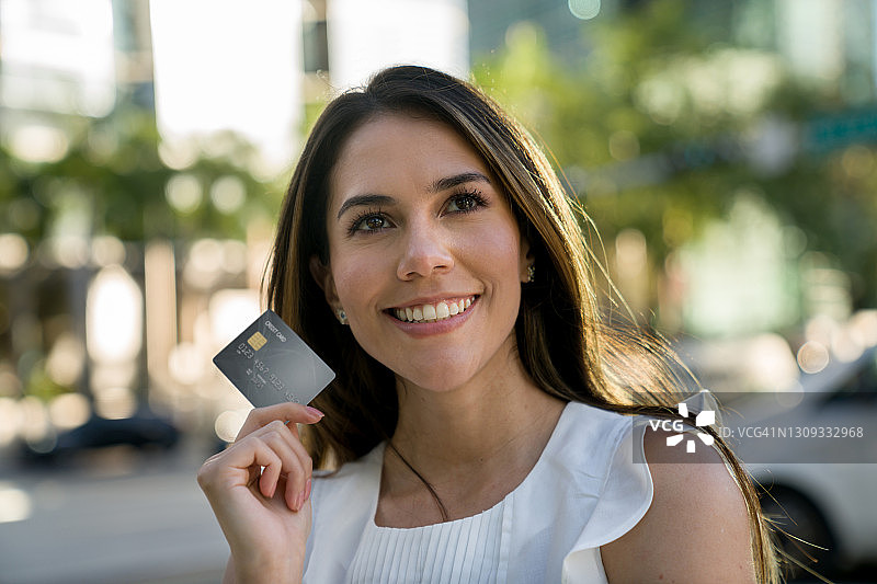 手持信用卡，思考购物的美丽女人图片素材