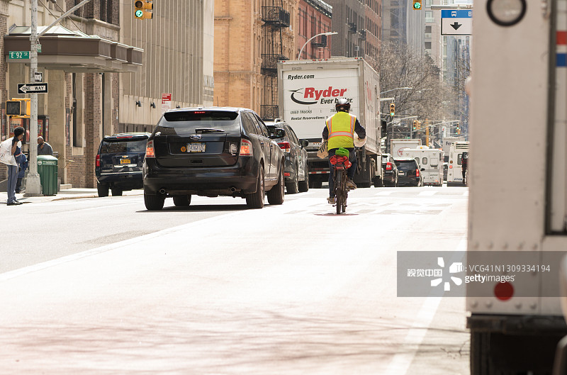 骑自行车在列克星敦大道公交车道上的送货员图片素材