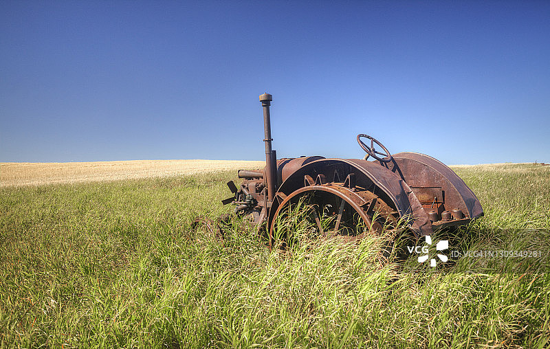田野中废弃的古董生锈拖拉机图片素材