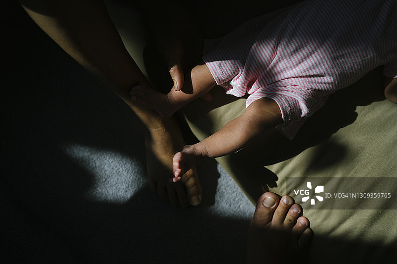 祖母抱着1个月大的宝宝在家晒太阳治疗黄疸图片素材