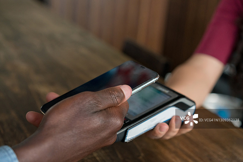 顾客使用智能手机支付账单图片素材