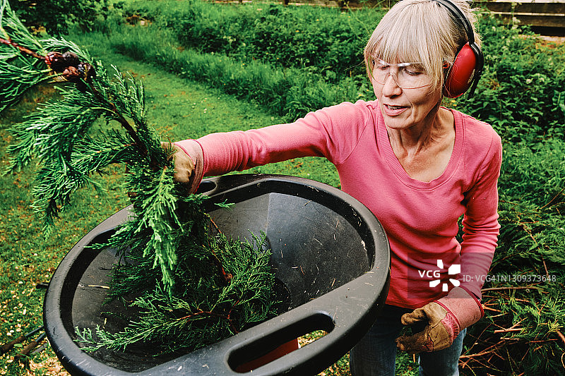 女人在花园里使用电动粉碎机图片素材