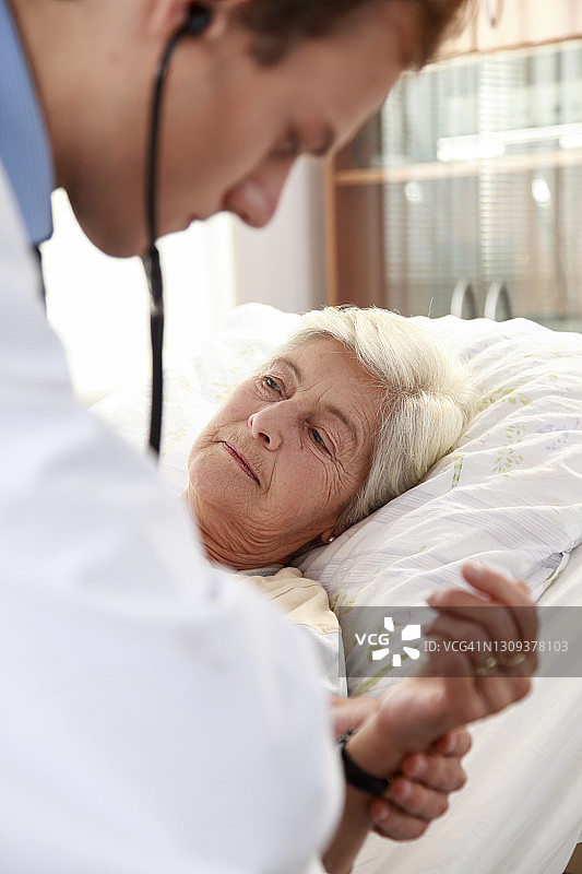 年轻医生检查年长的病人图片素材