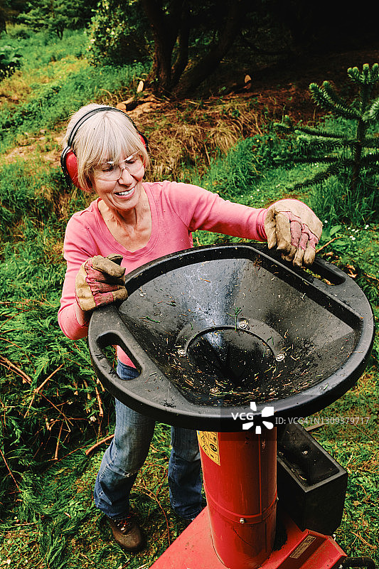 女人在花园里使用电动粉碎机图片素材