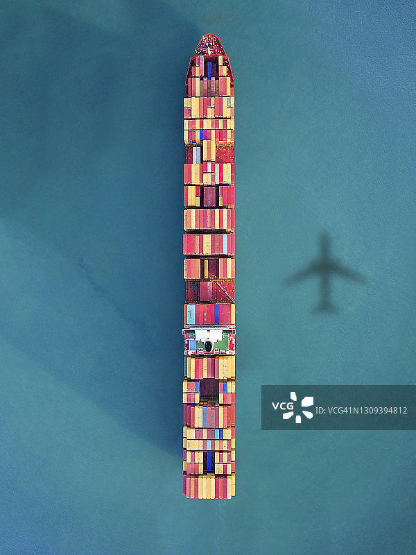 飞机飞越海洋中的集装箱船图片素材