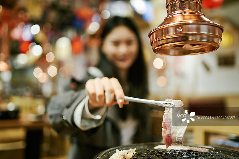 日式烤肉店里的年轻亚洲女孩，日式烤牛肉图片素材