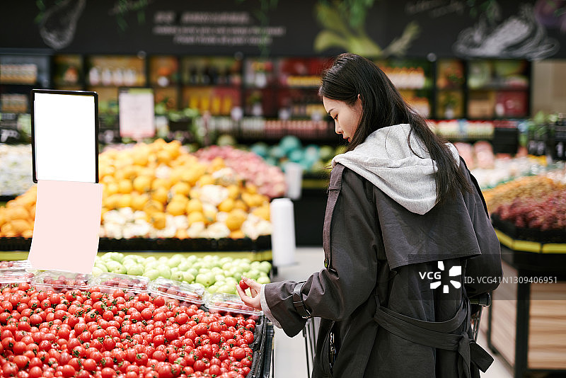 亚洲女孩在超市购买芒果图片素材