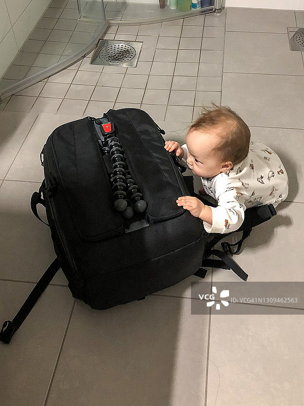 宝宝试图打开相机包图片素材