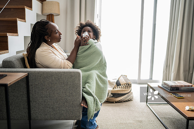 母亲使用雾化器为女儿量体温，进行吸入治疗图片素材