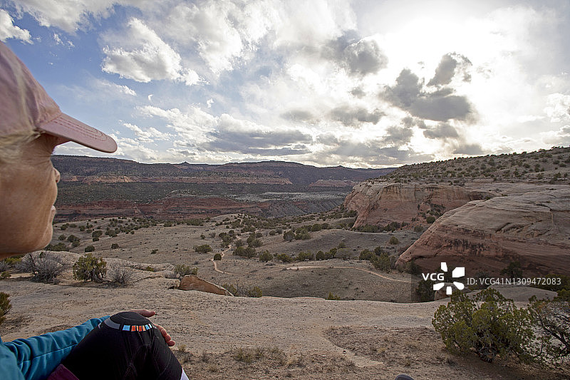 日落时峡谷边缘的年长徒步者肖像图片素材