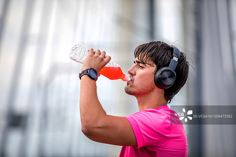 疲惫的运动员在户外运动训练中休息喝水。图片素材
