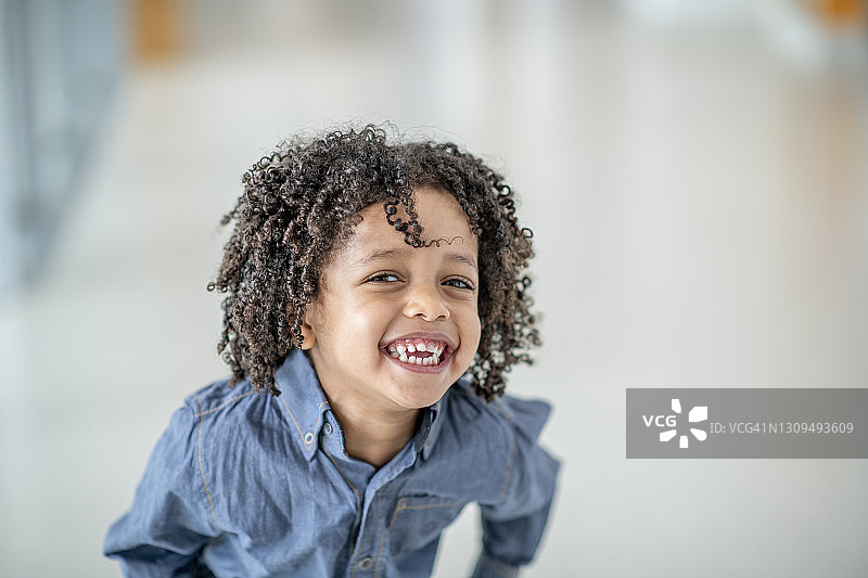 可爱四岁非洲男孩微笑看向镜头。图片素材