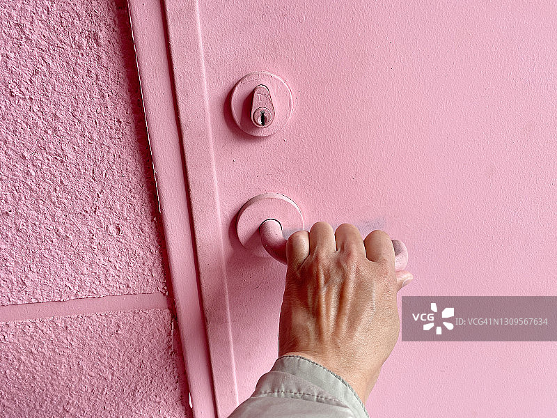 手握粉色门把手图片素材