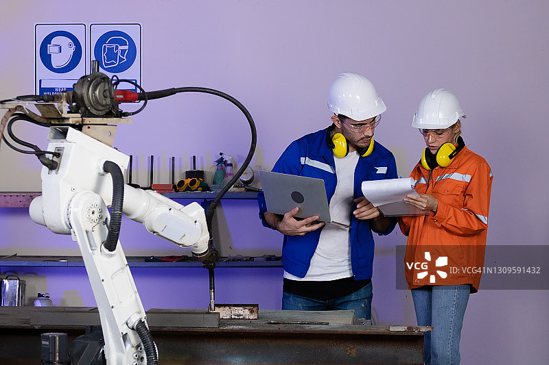 工程师与机器人在制造车间图片素材