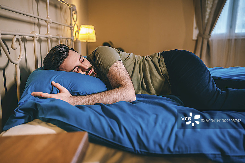 男人在家里的床上睡觉图片素材