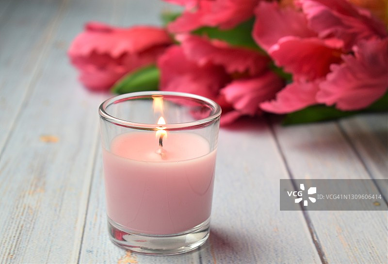 背景鲜花的粉色香薰蜡烛图片素材