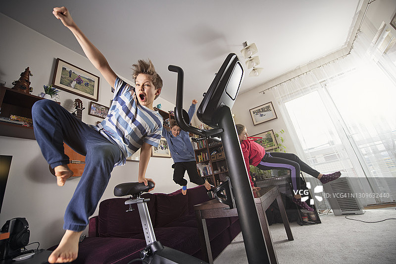 2019冠状病毒病大流行期间，孩子们在家里蹦蹦跳跳图片素材