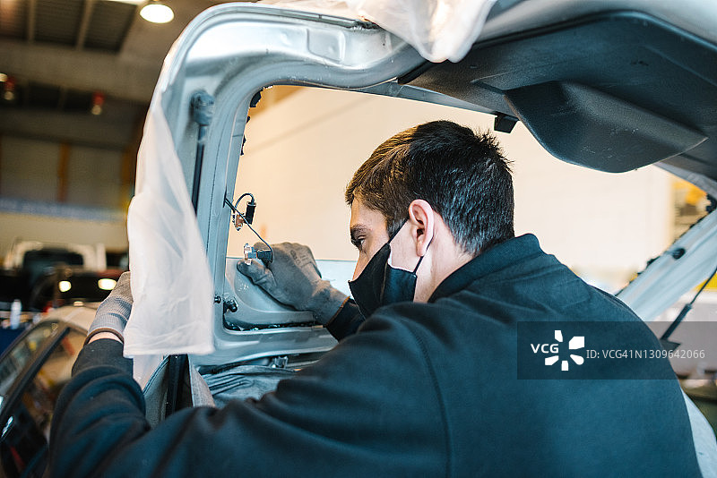 年轻技术员准备安装汽车后挡风玻璃图片素材