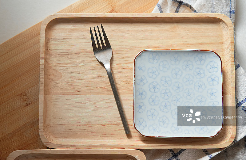 木质托盘上的餐叉和陶瓷盘图片素材