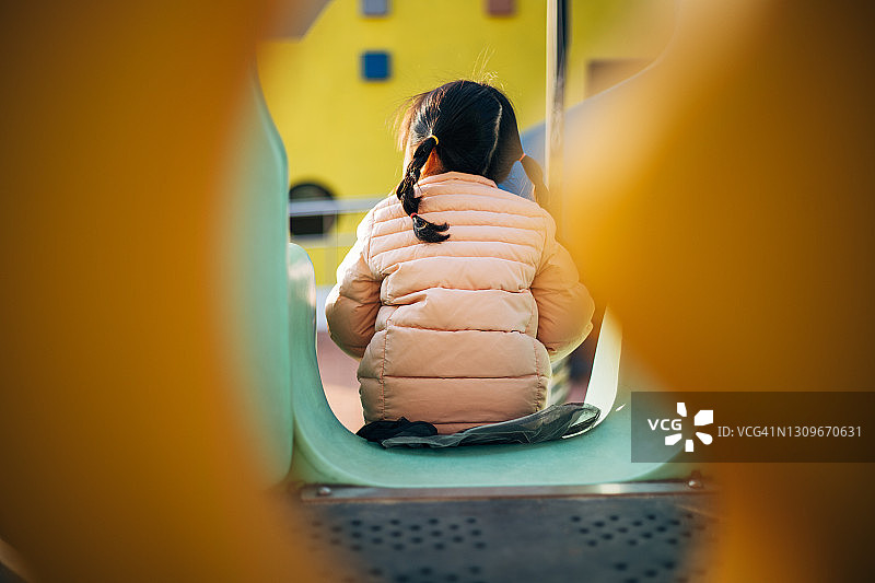 在操场滑梯上玩耍的快乐小女孩图片素材