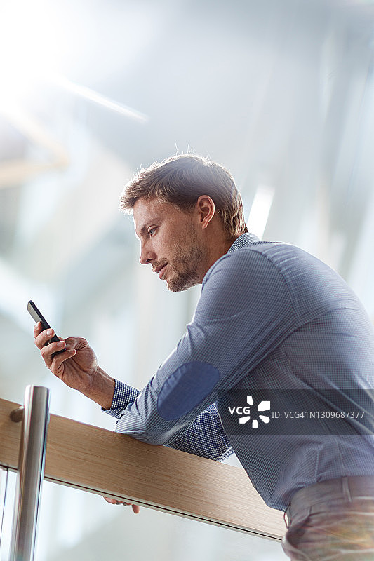 年轻商人用手机发短信图片素材