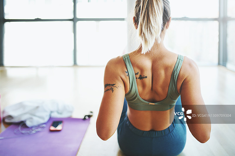 年轻女人在健身房做背部运动图片素材