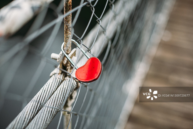 桥梁围栏上的红色心形挂锁图片素材