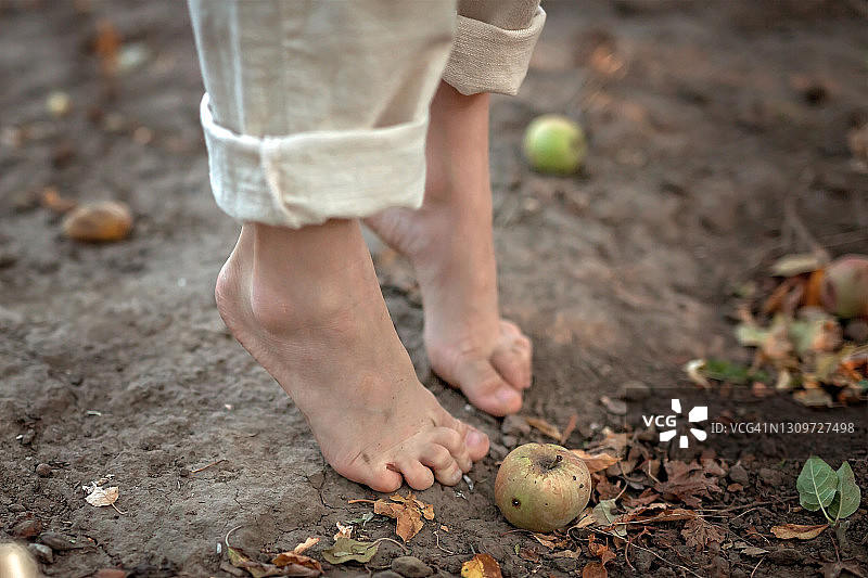 孩子光着脚站在地上，脚趾向上伸展，特写图片素材
