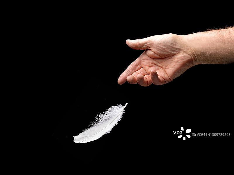 男人扔掉白色羽毛图片素材