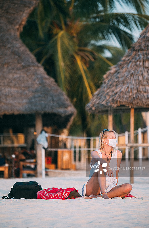 一位戴着防护面罩在海滩上的年轻女子图片素材